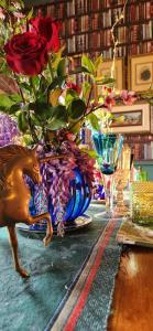un tavolo con un vaso blu con delle rose di Oak View Manor a Heidelberg