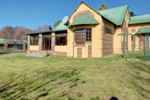 a house with a green roof and a yard at Mrs Simpson in Dullstroom