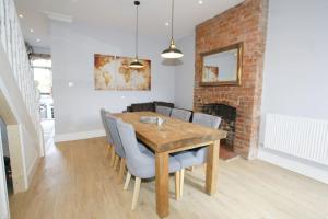 a dining room with a wooden table and chairs at Modern 4 bed house near city centre/Chester Zoo in Chester
