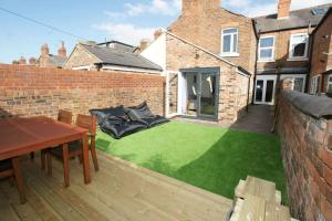 a small backyard with a green lawn at Modern 4 bed house near city centre/Chester Zoo in Chester