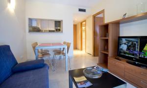 uma sala de estar com um sofá azul e uma mesa em Aparthotel Marsol em Castelldefels
