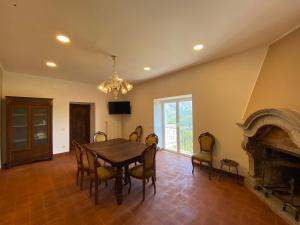 a dining room with a table and a fireplace at B&B La Cortesia in Turania