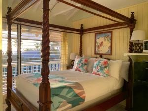 Big Island Retreat في كيلوا كونا: غرفة نوم مع سرير مظلة ونافذة