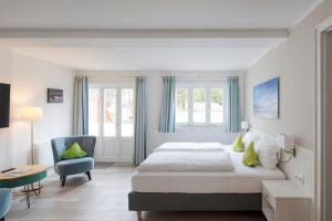een slaapkamer met een bed en een blauwe stoel bij Fitschen am Dorfteich in Wenningstedt