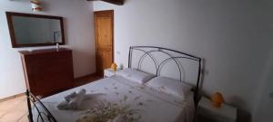 Schlafzimmer mit einem Bett mit weißer Bettwäsche und einem Spiegel in der Unterkunft Camera Vacanze Lusitana C in Foligno
