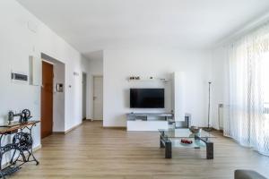 a living room with white walls and a flat screen tv at DomusMi Benedetto Marcello-28 in Milan