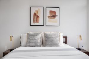 a bedroom with two framed art prints above a bed at Potomac Yard 1br w zen garden nr shops dining WDC-713 in Alexandria