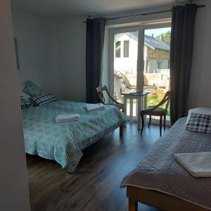 a bedroom with two beds and a large window at Pod Żurawiem Stegna in Stegna