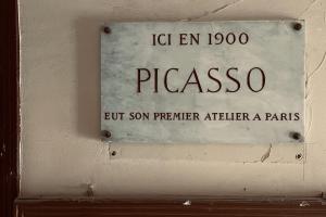 a sign on a wall that says paso but son son premier eighteen paralities at Design Picasso workshop 1900 in Paris
