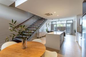 a kitchen and living room with a table and a staircase at Dunn Bay Apartment 5 - Dunsborough in Dunsborough