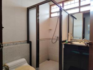 a bathroom with a shower and a toilet and a sink at Rumah Oma Lembang for Family & Friends in Lembang +26 photos