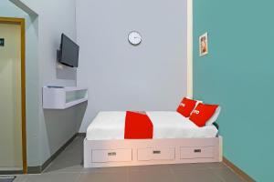 een kleine slaapkamer met een bed en een televisie bij OYO Life 92691 Mc Kost Syariah in Jambi