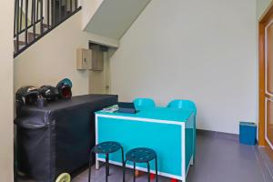 Habitación con 2 sillas y mesa con 2 taburetes en OYO Life 92691 Mc Kost Syariah, en Jambi