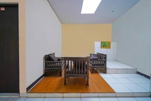 two benches sitting in a room with a wall at OYO Life 92641 Guest House Palinggihan Ii in Cirebon