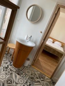 a bathroom with a sink and a mirror at Hôtel de la Pinède in Juan-les-Pins