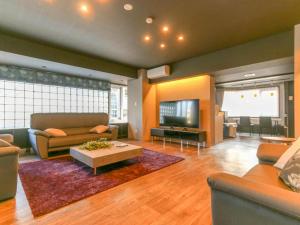 a large living room with couches and a tv at Kamuy Rera in Kushiro