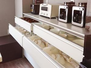 a kitchen with white drawers and appliances at Kamuy Rera in Kushiro