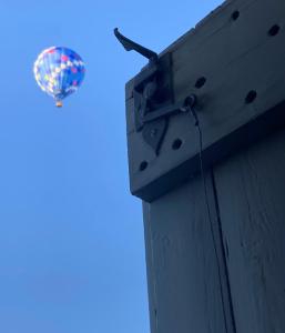 a hat is hanging on the side of a building at le secret du chat in Cordes-sur-Ciel