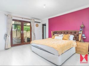 Un dormitorio con una pared rosa y una cama en Leisurehome en Perth
