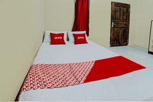 een bed met twee rode kussens erop bij OYO Life 93058 Kos Subur in Tanjung