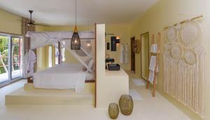 ein Schlafzimmer mit einem Himmelbett in der Unterkunft Alma Boutique Hotel in Jambiani
