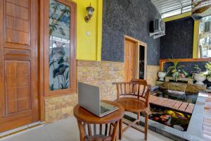 een laptop op een tafel in een kamer bij OYO Life 92840 Wisma Morricco in Jombang