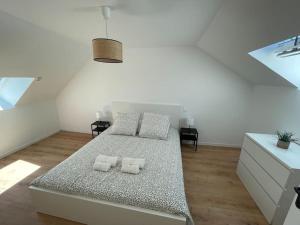 een witte slaapkamer met een bed met 2 kussens bij Maison 6 chambres in Clohars-Carnoët