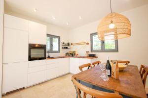 a kitchen and dining room with a wooden table at TD Trulli Tortorella with Nature Pool Sauna in Monopoli