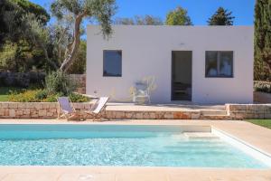 a villa with a swimming pool and a house at TD Trulli Tortorella with Nature Pool Sauna in Monopoli