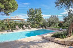 a swimming pool with chairs and an umbrella at TD Trulli Tortorella with Nature Pool Sauna in Monopoli