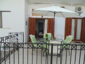 a table and chairs with an umbrella on a balcony at Maria Studios in Skiathos