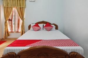 - une chambre dotée d'un lit avec une couverture rouge et blanche dans l'établissement OYO Life 92803 Penginapan Purnama, à Kayuagung