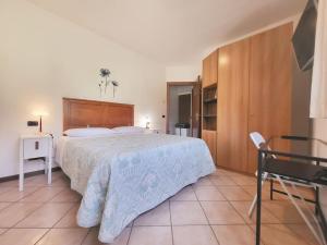 イントラにあるNido dei Gelsi vicino al lago free parkingのベッドルーム1室(大型ベッド1台、木製ヘッドボード付)