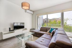 a living room with a couch and a tv at Annitchka Mansions - Apartment in central Malta in Birkirkara