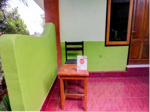 a small table in front of a room with green at OYO Life 92829 Kos Insan Madani in Praya