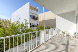 un balcón de una casa con barandilla blanca en Annitchka Mansions - Apartment in central Malta, en Birkirkara