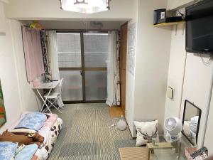 a small room with a bed and a television at 新宿の家-畳み3人部屋 in Tokyo