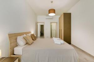 een slaapkamer met een groot wit bed in een kamer bij Annitchka Mansions - Apartment in central Malta in Birkirkara