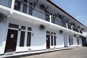 uma fila de portas num edifício branco em OYO Life 92886 Rumah Nyaman Radhika 2 Syariah em Tuban
