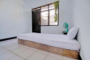 a bed in a room with a window at OYO Life 92901 Kost Bu Nur in Bandung