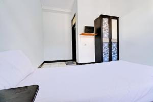 a white room with a refrigerator and a bed at OYO Life 92901 Kost Bu Nur in Bandung