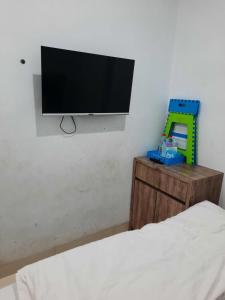 uma televisão de ecrã plano pendurada numa parede num quarto em OYO Life 92883 Kost Ratana Cengkareng Syariah em Jakarta