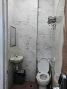 uma casa de banho branca com um WC e um lavatório em OYO Life 92883 Kost Ratana Cengkareng Syariah em Jakarta