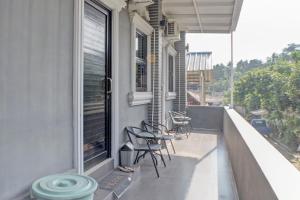 d'un balcon avec des chaises et une fenêtre sur une maison. dans l'établissement OYO Life 92830 Homestay Slamet Riadi Iv, à Bandar Lampung