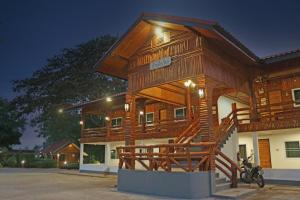 un grande edificio in legno con una scala di fronte di Baan Khue Wieng Resort a Mae Sariang