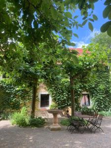 due panche e una fontana di fronte a un edificio di Uhlenmühle a Aub