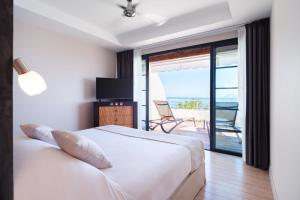 a bedroom with a bed and a view of the ocean at Te Moana Tahiti Resort in Punaauia