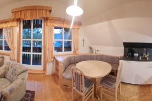 a living room with a table and a couch at Uriges Landgasthaus in Modriach in Modriach