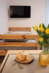 einen Tisch mit einem Tablett Brot und einer Vase Blumen in der Unterkunft Zubrzyckie Pokoje in Zubrzyca Dolna