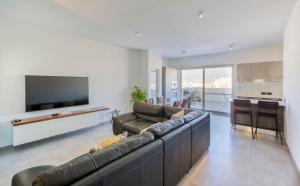uma sala de estar com um sofá grande e uma televisão em Annitchka Mansions - Penthouse in central Malta em Birkirkara